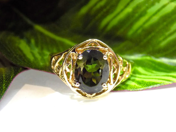 This is a women's natural green tourmaline ring with a 1.70ct genuine oval shape green tourmaline set in a filigree style mounting in 10K yellow gold with a green leaf background.