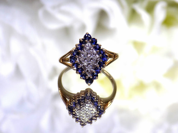 This is a refurbished vintage genuine sapphire & diamond cluster ring in yellow gold with a flowery background.