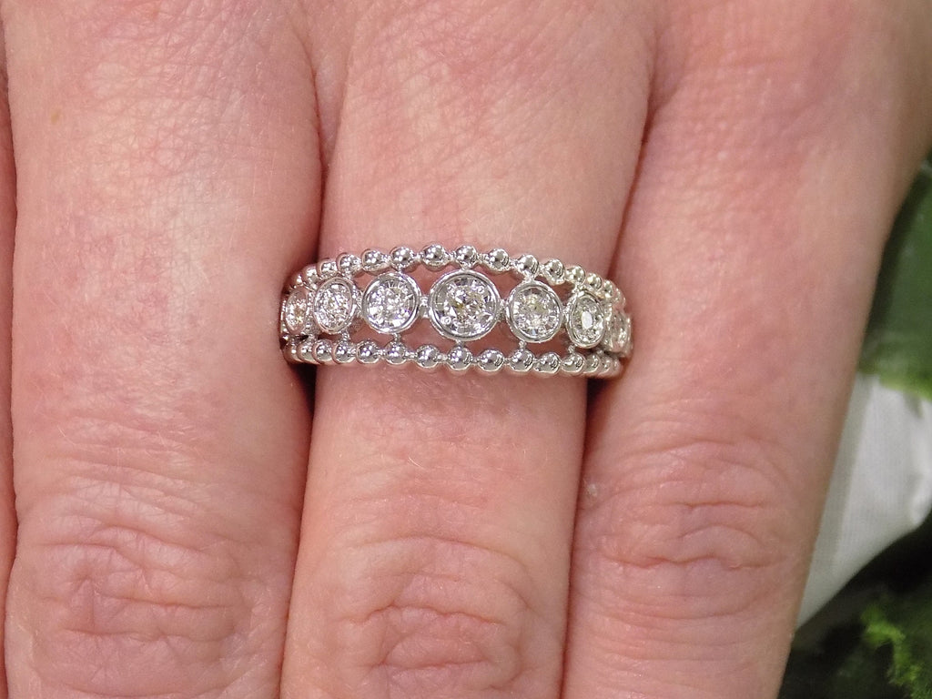 .20ct bezel set natural round brilliant diamond ring in 10K white gold on a ladies finger.
