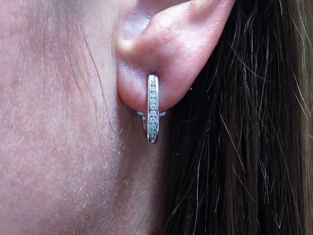 "J" hoop .25ct natural diamond earrings channel set in 10K white gold in a ladies ear.