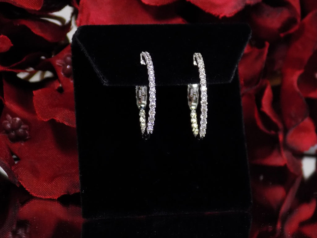 This is .50ct total weight natural diamond inside out hoop earrings in 10K white gold on a black pad with a red floral background.