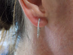 This is .50ct total weight natural diamond inside out hoop earrings in 10K white gold in a ladies ear.