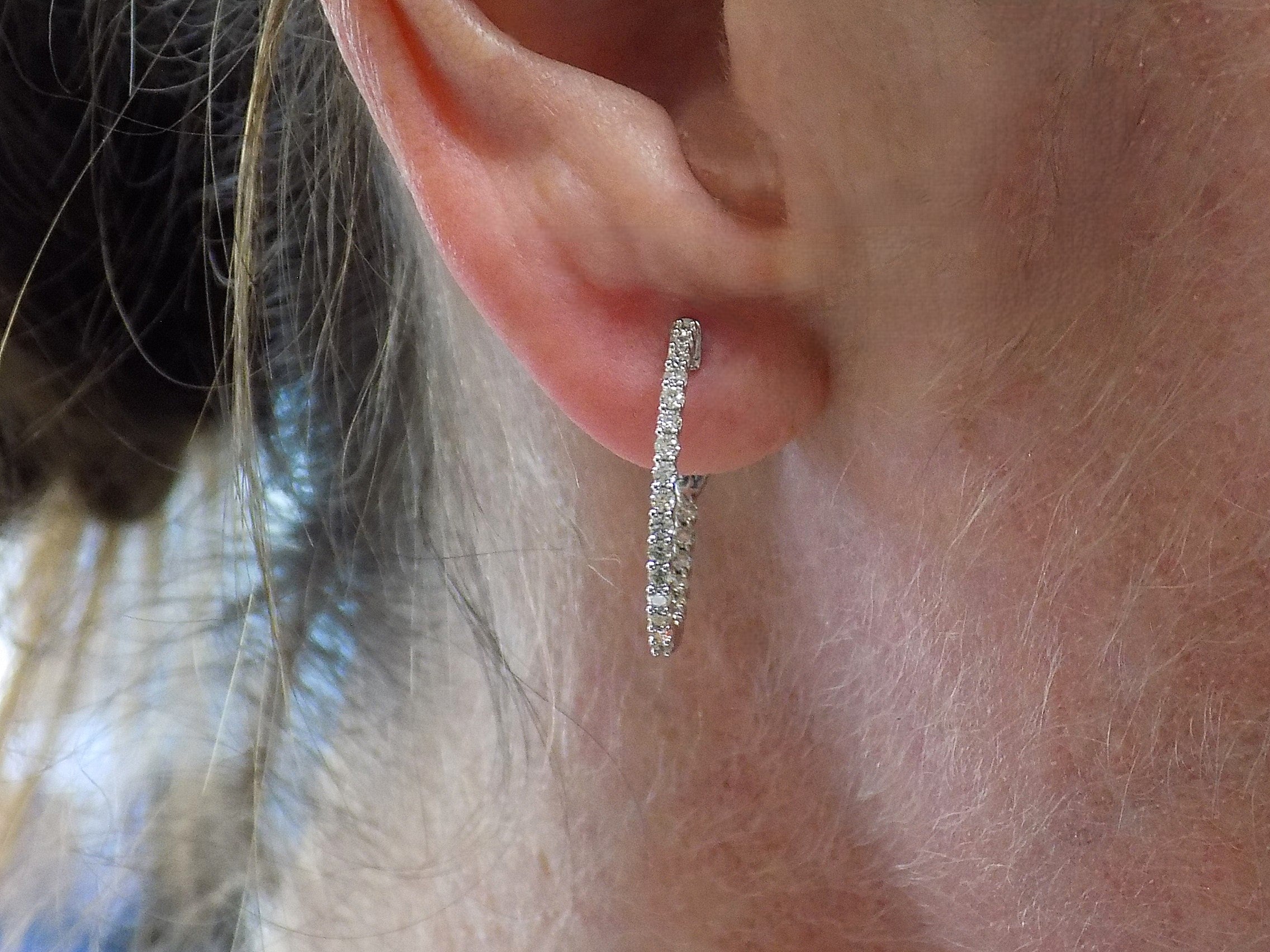This is .50ct total weight natural diamond inside out hoop earrings in 10K white gold in a ladies ear.