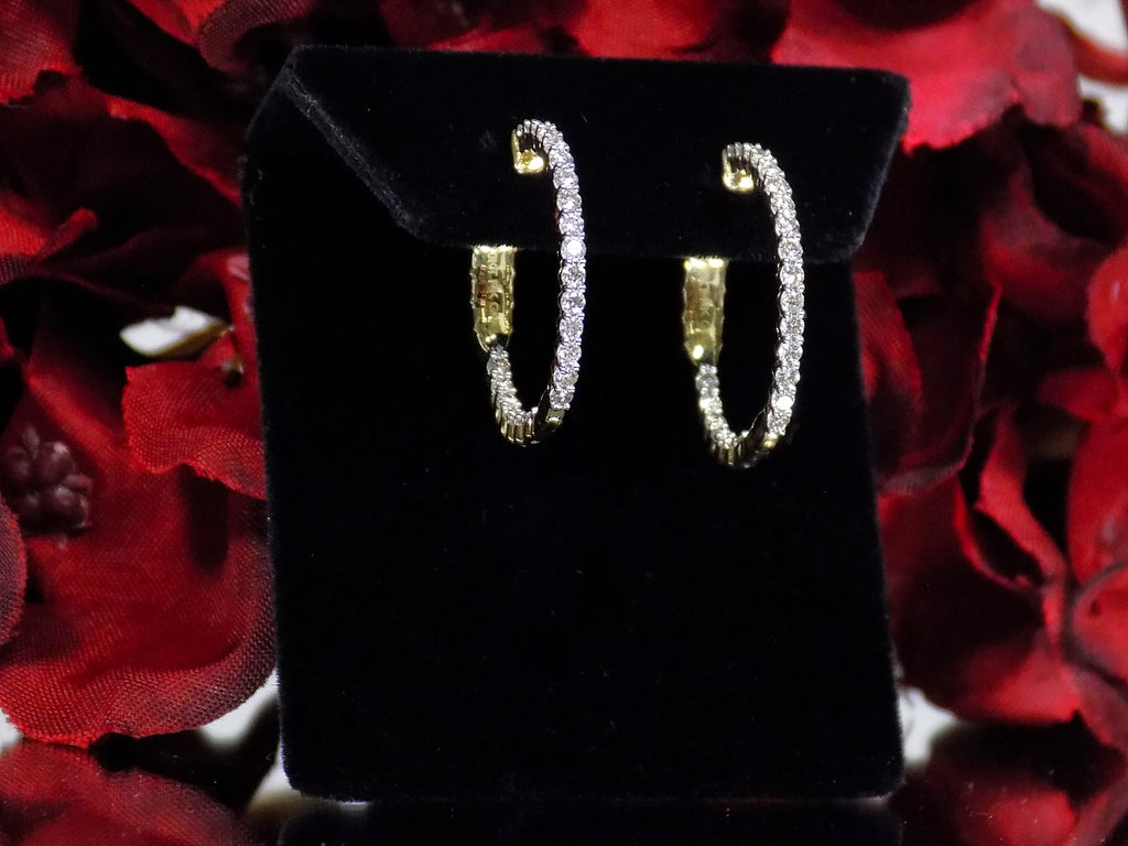 This is .50ct total weight natural diamond inside out hoop earrings in 10K yellow gold on a black pad with a red floral background.
