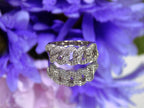 This is a .50ct natural pave set round diamond band in white gold with a blue mirrored flowery background.
