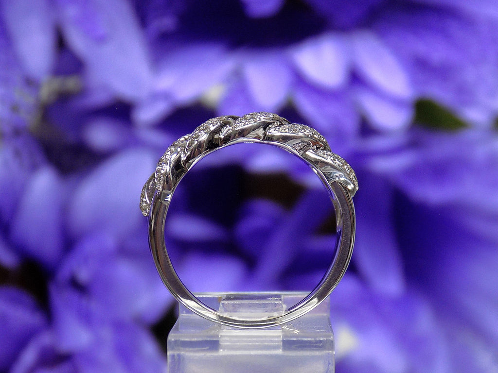 This is a side view of a .50ct natural pave set round diamond band in white gold with flowery background.