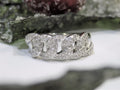 This is a .50ct natural pave set round diamond band in white gold with flowery background.