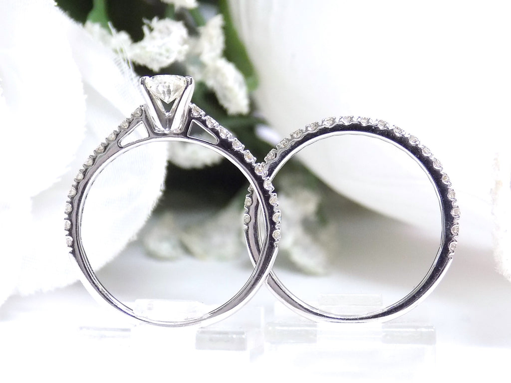 This is the side view of a natural oval shape diamond wedding set ring with matching band in white gold with a white background.