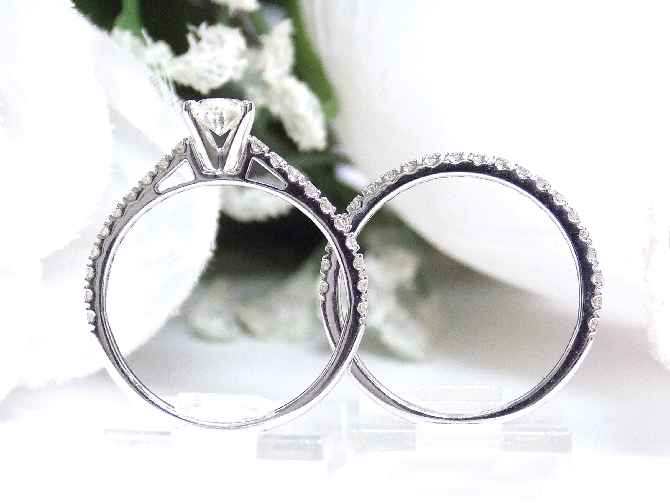 This is the side view of a natural oval shape diamond wedding set ring with matching band in white gold with a white background.