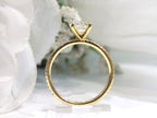 This is a side view of a women's natural round brilliant diamond ring with a 1.02ct center and .23ct in accents diamonds set in yellow gold shown with white background.