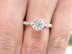 This is a women's 1.72ct total weight natural round diamond engagement ring in white gold shown on a woman's finger.