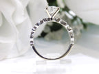 This is a side view of a women's 1.72ct total weight natural round diamond engagement ring in white gold shown with white background.
