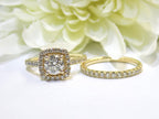 This is a halo style 2-piece wedding set which includes the engagement ring and a matching band for a total of 1.77ct in natural round diamonds shown side by side with yellow white flowery background.