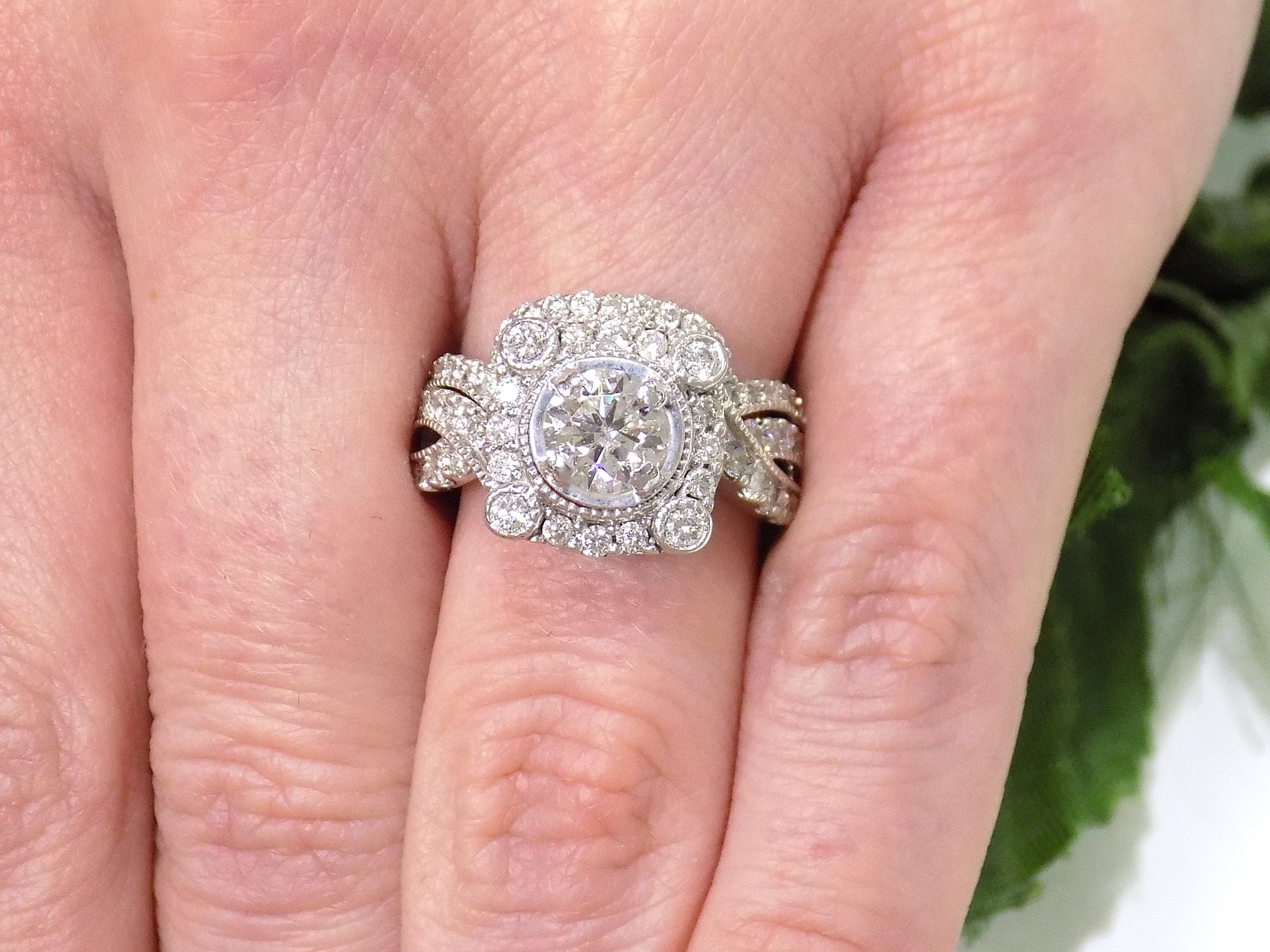 The is a 1.95ct total weight natural 2-piece natural round diamond wedding set with engagement ring and matching band already tacked together from our estate collection in white gold shown on a woman's finger.