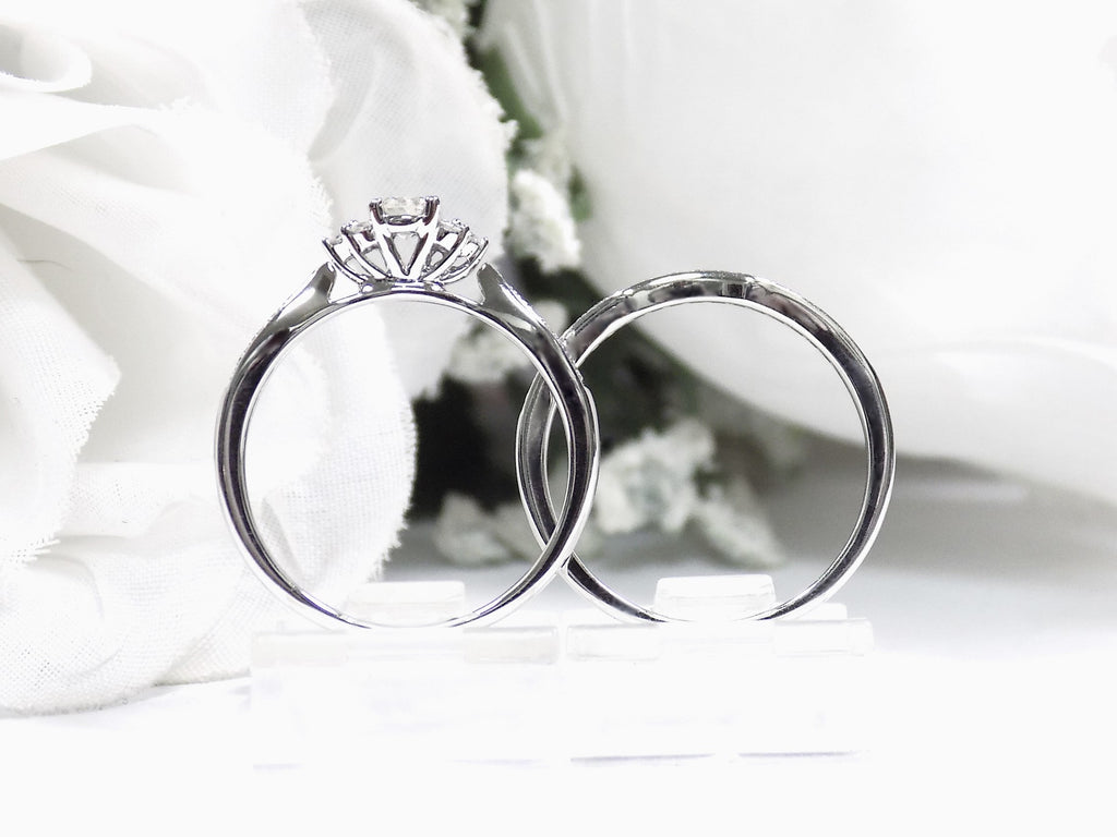 This is a two piece diamond wedding set with the ring and matching band in white gold shown from a side view white background. 