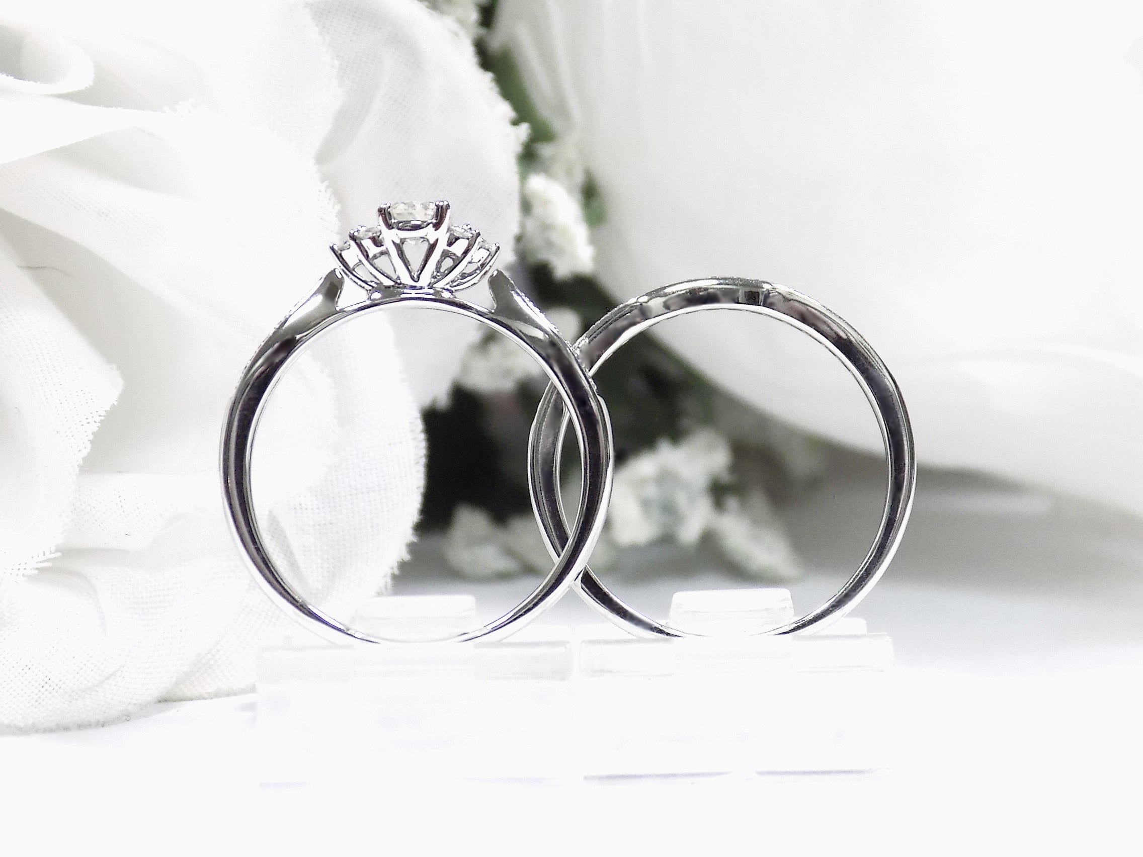 This is a two piece diamond wedding set with the ring and matching band in white gold shown from a side view white background. 