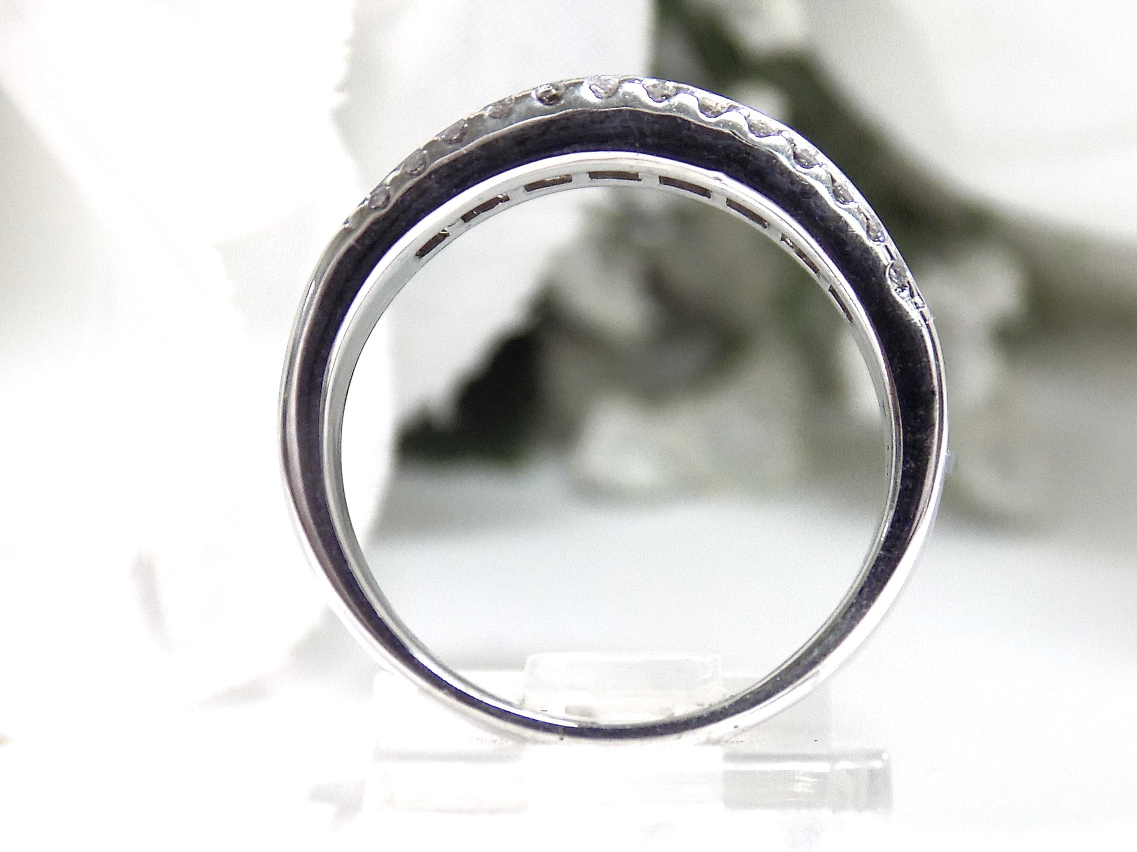 This is a side view of a 3-row channel & prong set 1.00ct total weight natural wide diamond band in white gold with a white background. 