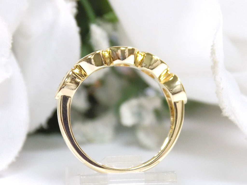 This is a side view of a bezel set 5-stone natural 1ct total weight diamond band in yellow gold with a white background.