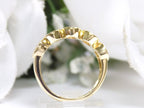 This is a side view of a bezel set 5-stone natural 1ct total weight diamond band in yellow gold with a white background.