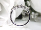 This is a side view of a 5-Stone natural diamond band in white gold with a white gold background.