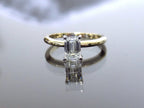 This is a ladies' 1.11ct emerald cut natural diamond solitaire ring in yellow gold with mirrored background.