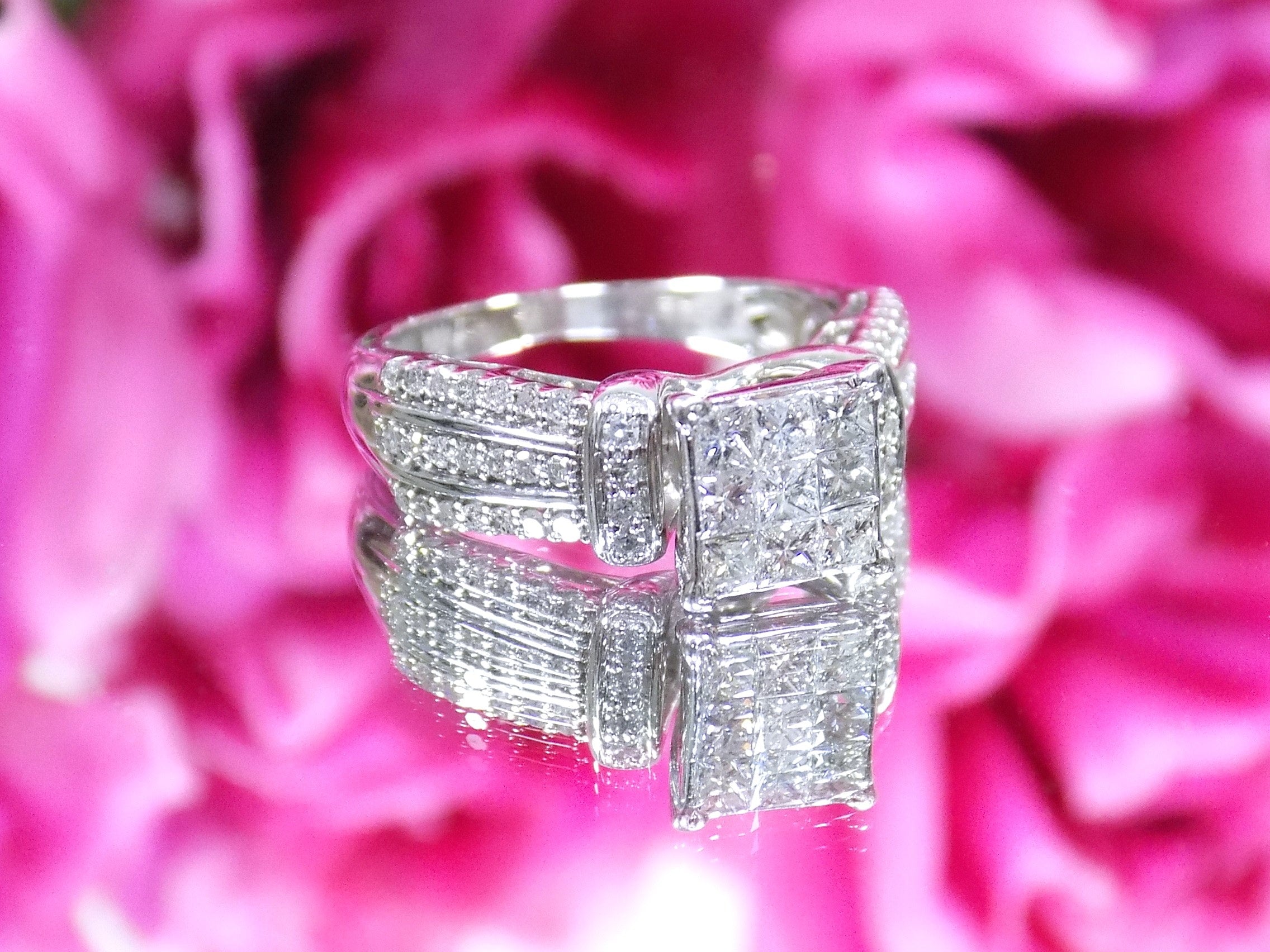 This is a 1.00ct total weight natural diamond ring in white gold shown with a pink floral background.