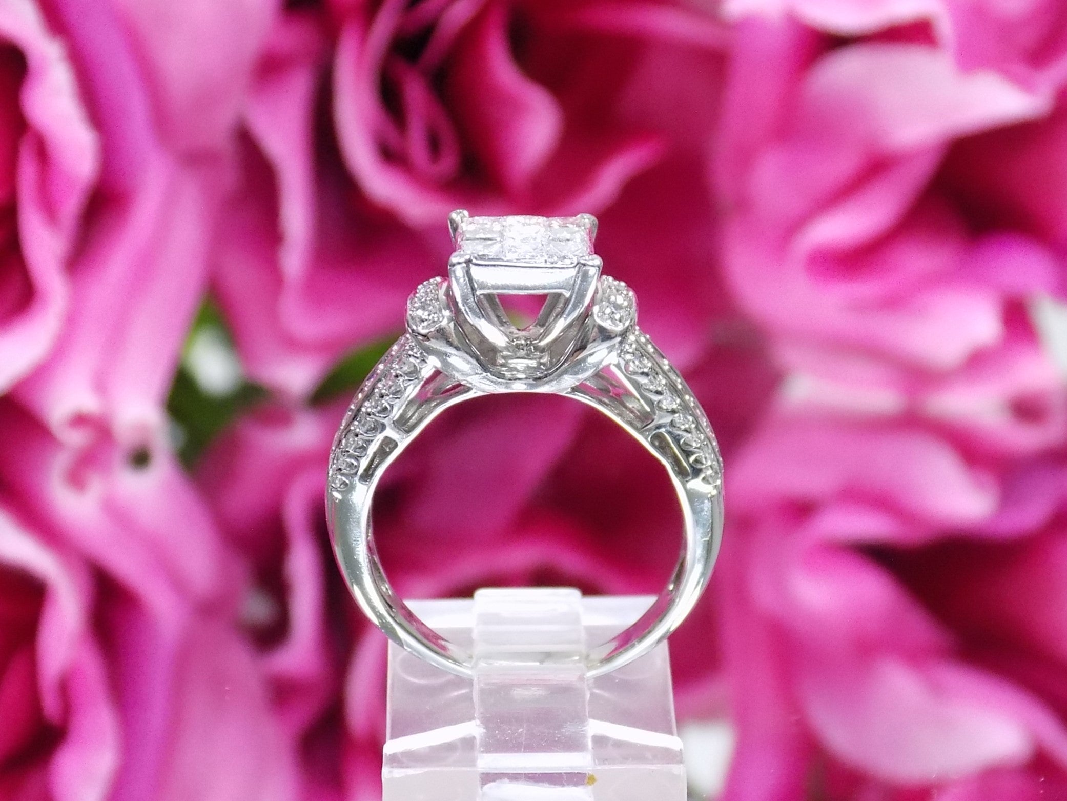 This is a side view of a 1.00ct total weight natural diamond ring in white gold shown with a pink floral background.