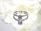This a 1ct total weight natural oval shape diamond set on a straight line diamond band in white gold.