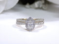 This is 2-piece natural oval shape diamond wedding set weighing 1ct total with both the engagement ring and matching band in yellow gold with white gold prongs and a white background