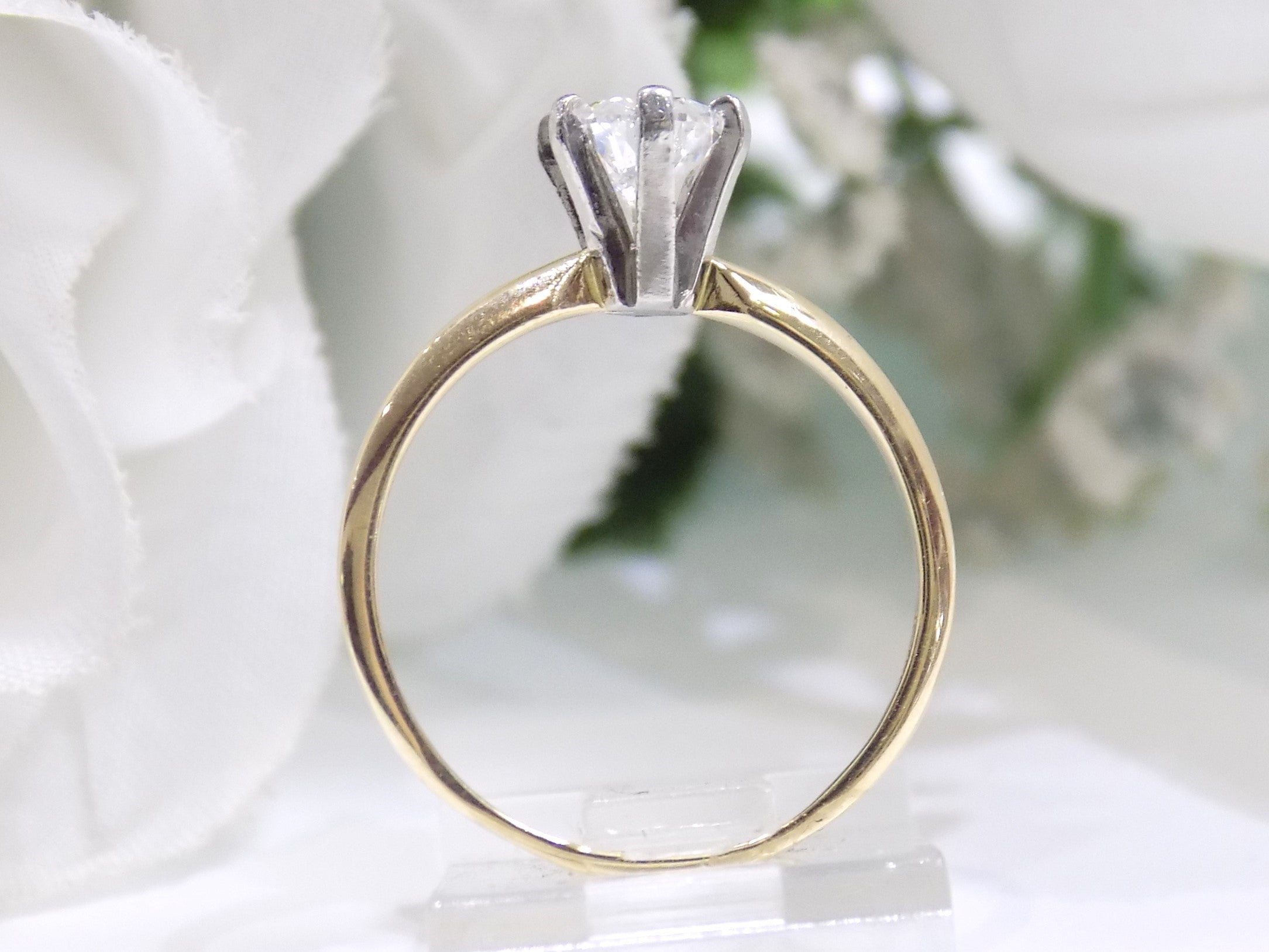 This is side view of a high quality 1.00ct natural pear shape diamond solitaire ring in yellow gold with a white background.