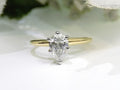 This is high quality 1.00ct natural pear shape diamond solitaire ring in yellow gold with a white background.