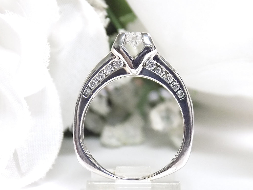 This is side view of a 1ct total weight natural round diamond ring in white gold with a white background.