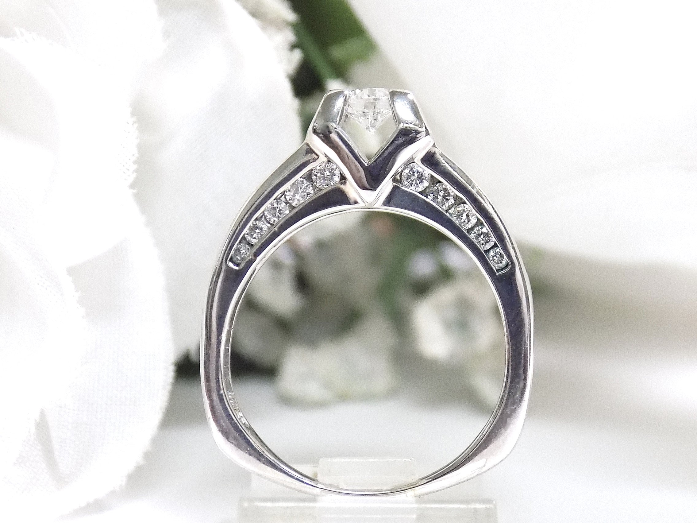 This is side view of a 1ct total weight natural round diamond ring in white gold with a white background.