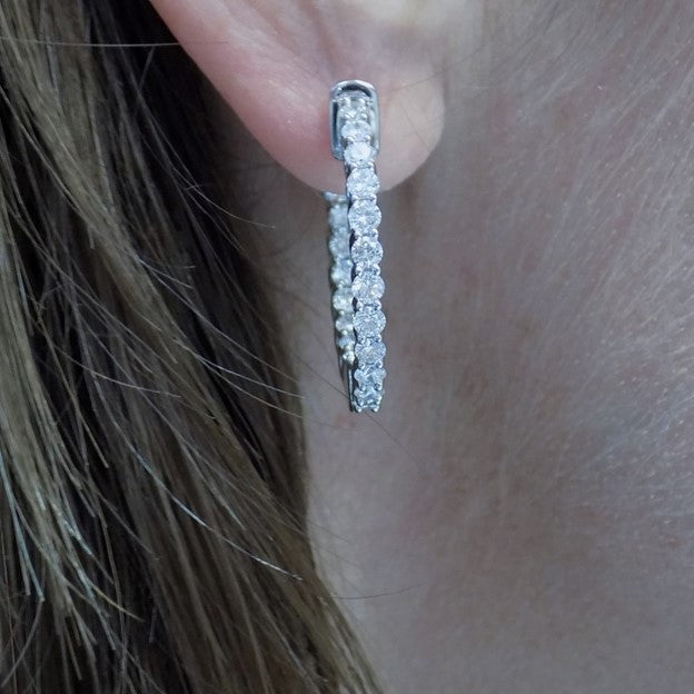 This is 2.00ct total weight natural round brilliant diamond earrings 1" in diameter inside out style earrings in 14K white gold in a ladies ear.