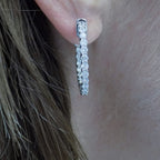 This is 2.00ct total weight natural round brilliant diamond earrings 1" in diameter inside out style earrings in 14K white gold in a ladies ear.