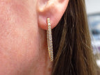 2.00ct total weight natural diamond in and out style oval hoops in 14K yellow gold in a ladies ear.