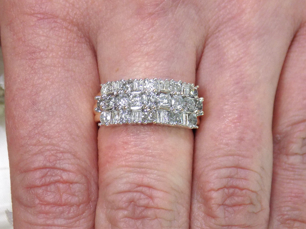 This is a vintage 2.00ct total weight round brilliant and baguette diamond band in two tone 14K yellow and white gold on a ladies finger.