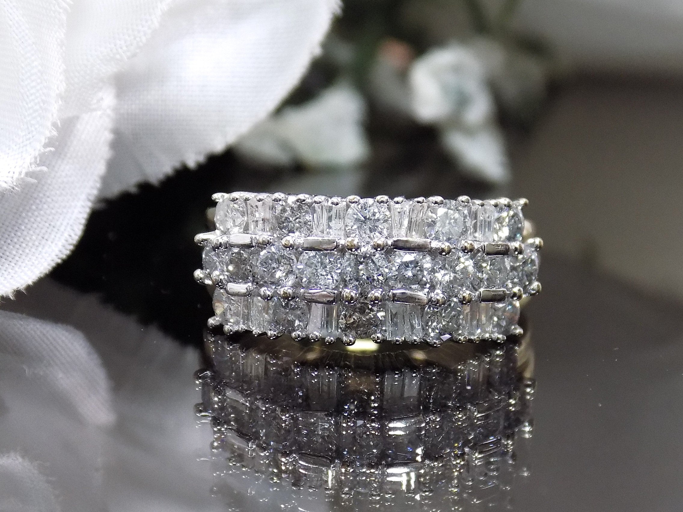 This is a vintage 2.00ct total weight round brilliant and baguette diamond band in two tone 14K yellow and white gold on a black background.