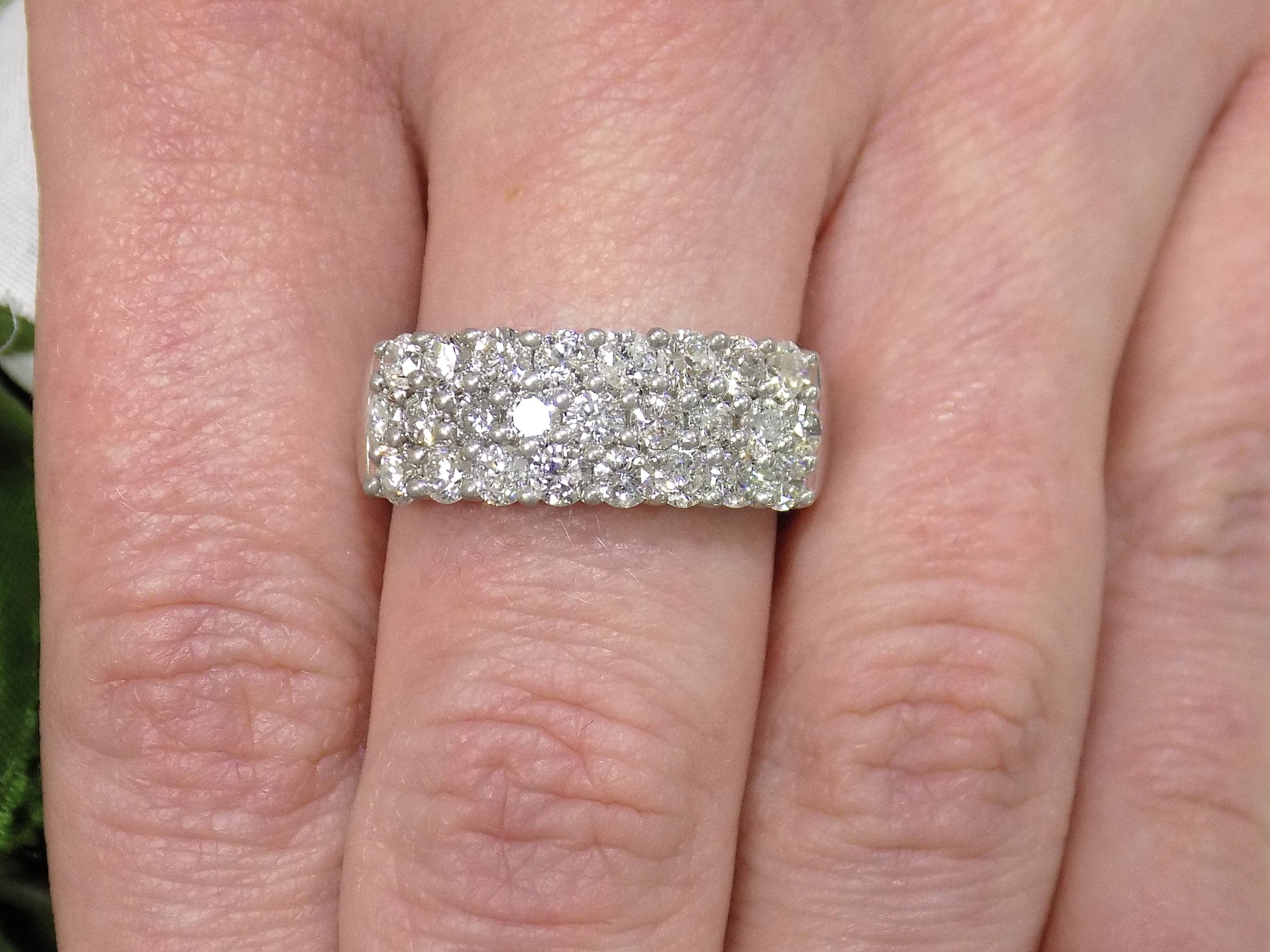 This is an estate 3-row 2.00ct total weight natural diamond band 8.2mm wide in 14K white gold on a ladies finger.