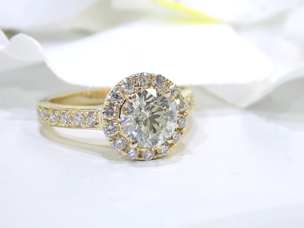 This is halo style 2.17ct total weight natural round diamond ring with a 1.52ct center diamond in yellow gold with a white background.