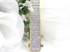 This is a 22.00ct natural princess cut diamond bracelet with 76.4 grams of 18K yellow gold with a white floral background.