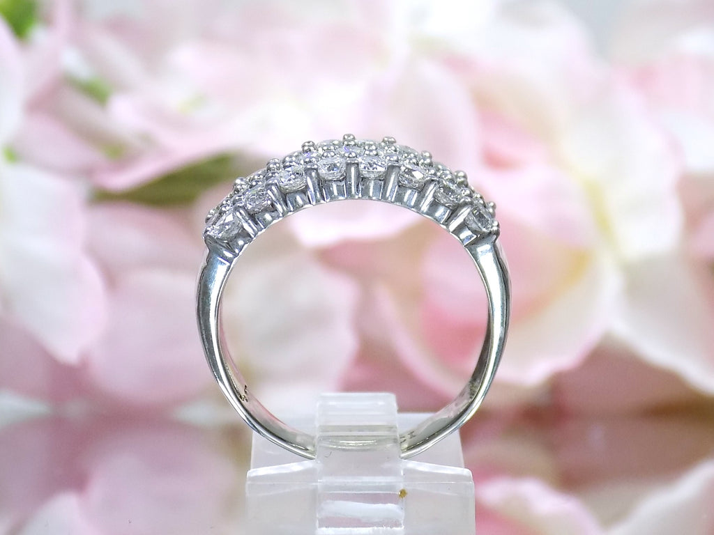 This is an estate 3-row 2.00ct total weight natural diamond band 8.2mm wide in 14K white gold on a mirrored surface side view with a pink floral background.