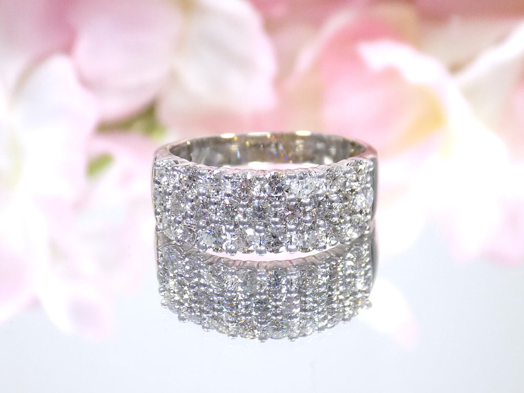 This is an estate 3-row 2.00ct total weight natural diamond band 8.2mm wide in 14K white gold on a mirrored surface with a pink floral background.