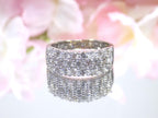 This is an estate 3-row 2.00ct total weight natural diamond band 8.2mm wide in 14K white gold on a mirrored surface with a pink floral background.