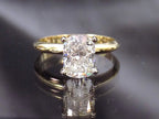 This is a 2.01ct natural elongated cushion cut diamond solitaire in yellow gold with a grayish mirrored background.