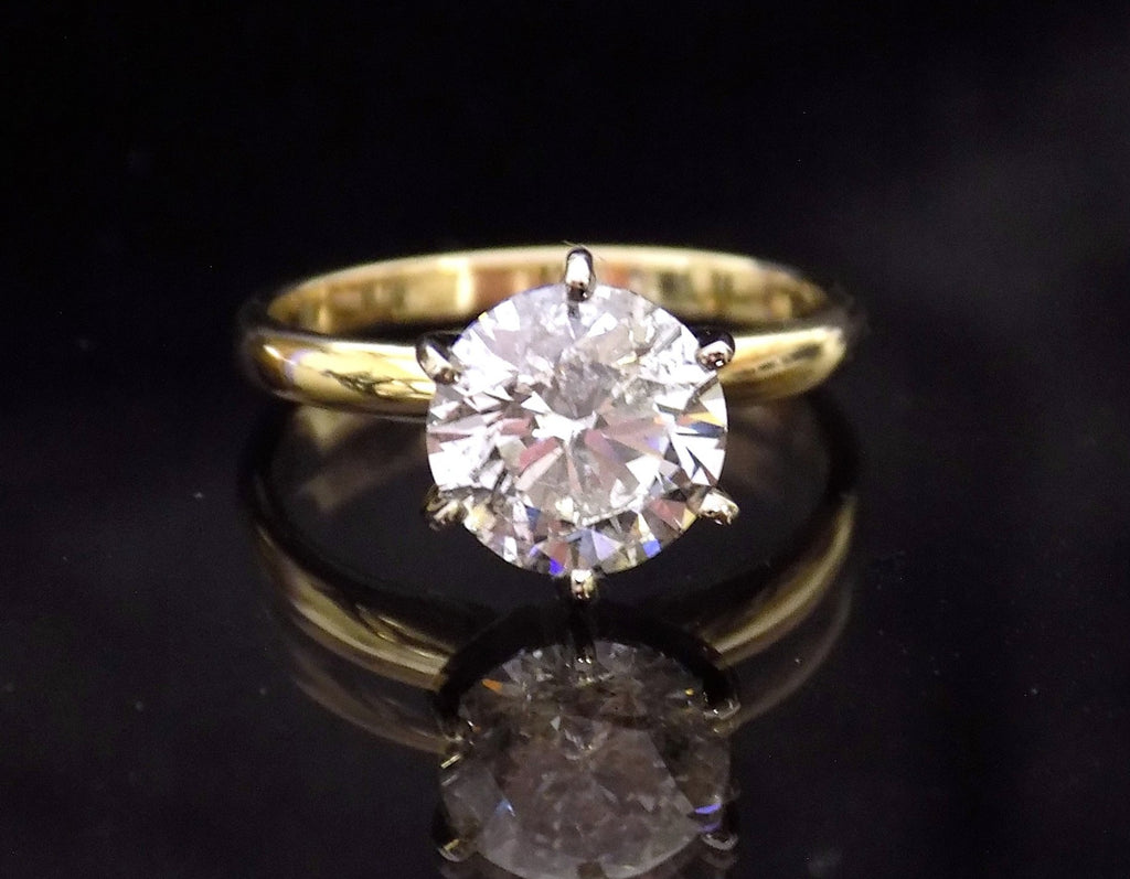 This is a 2.20ct natural round brilliant diamond solitaire in yellow gold with a black mirrored background.