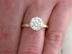 This is a 2.20ct natural round brilliant diamond solitaire in yellow gold shown on a woman's finger.