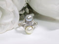 This is fully restored like new 2-pearl ring one gray and one white pearl with diamond accents shown on a white background.