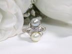 This is fully restored like new 2-pearl ring one gray and one white pearl with diamond accents shown on a white background.
