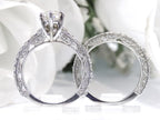 This is a side view of a women's 2-piece wedding set including the engagement ring and a matching band with a 1.51ct natural pear shape diamond center plus 1.64ct in natural diamond accents shown side by side on white background.